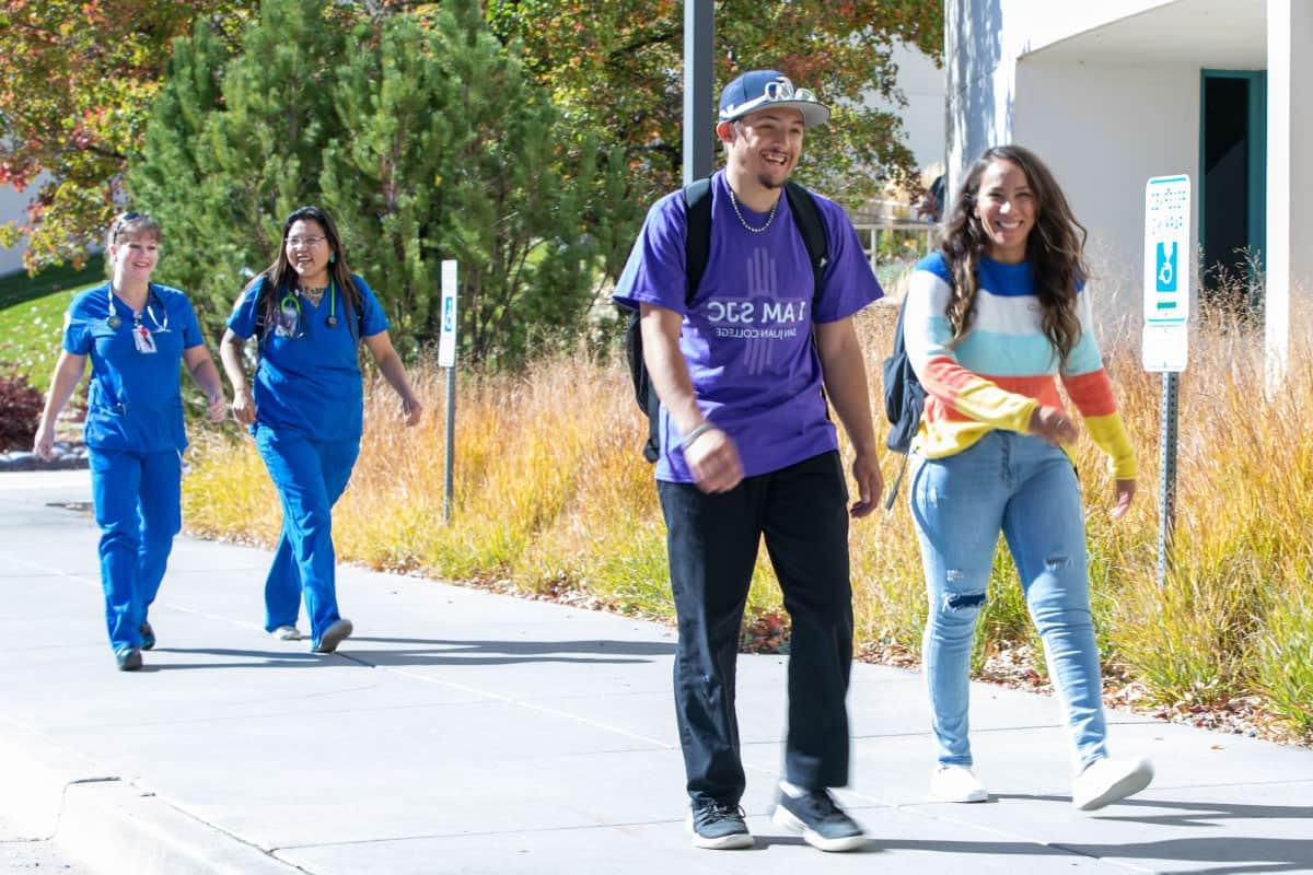 Happy students walking up sidewalk